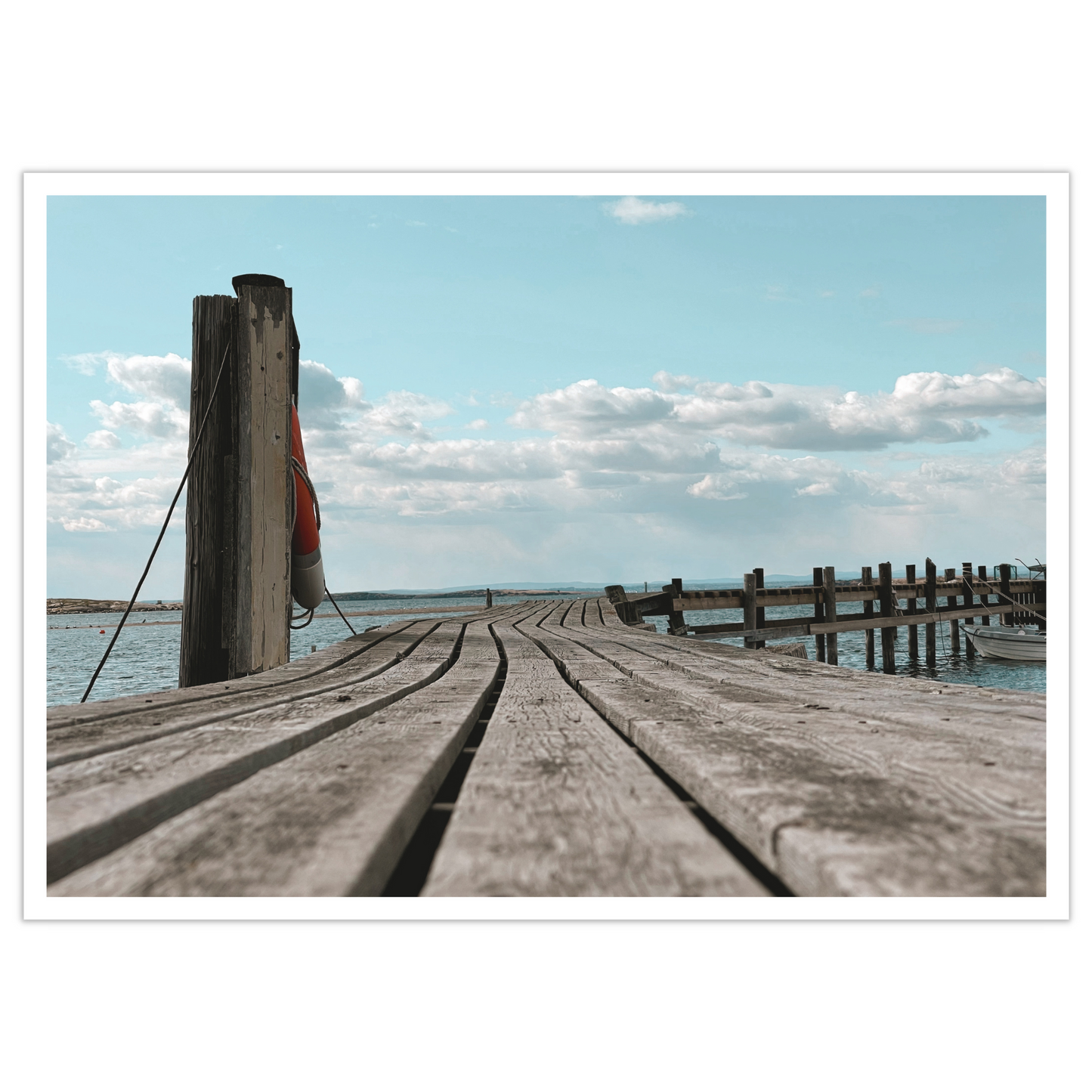 Gammel brygge, sjø, blå himmel og hvite skyer ved Saltholmen, Saltnes. Vakkert norsk kystlandskap i Østfold som vil være dekorativ på en fotoplakat. 