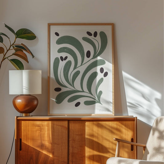 Skap en rolig og naturlig atmosfære i hjemmet ditt med Olivenblad, en minimalistisk botanisk kunstplakat som kombinerer tidløs eleganse med moderne enkelhet. Illustrasjon viser plakat i eik ramme.