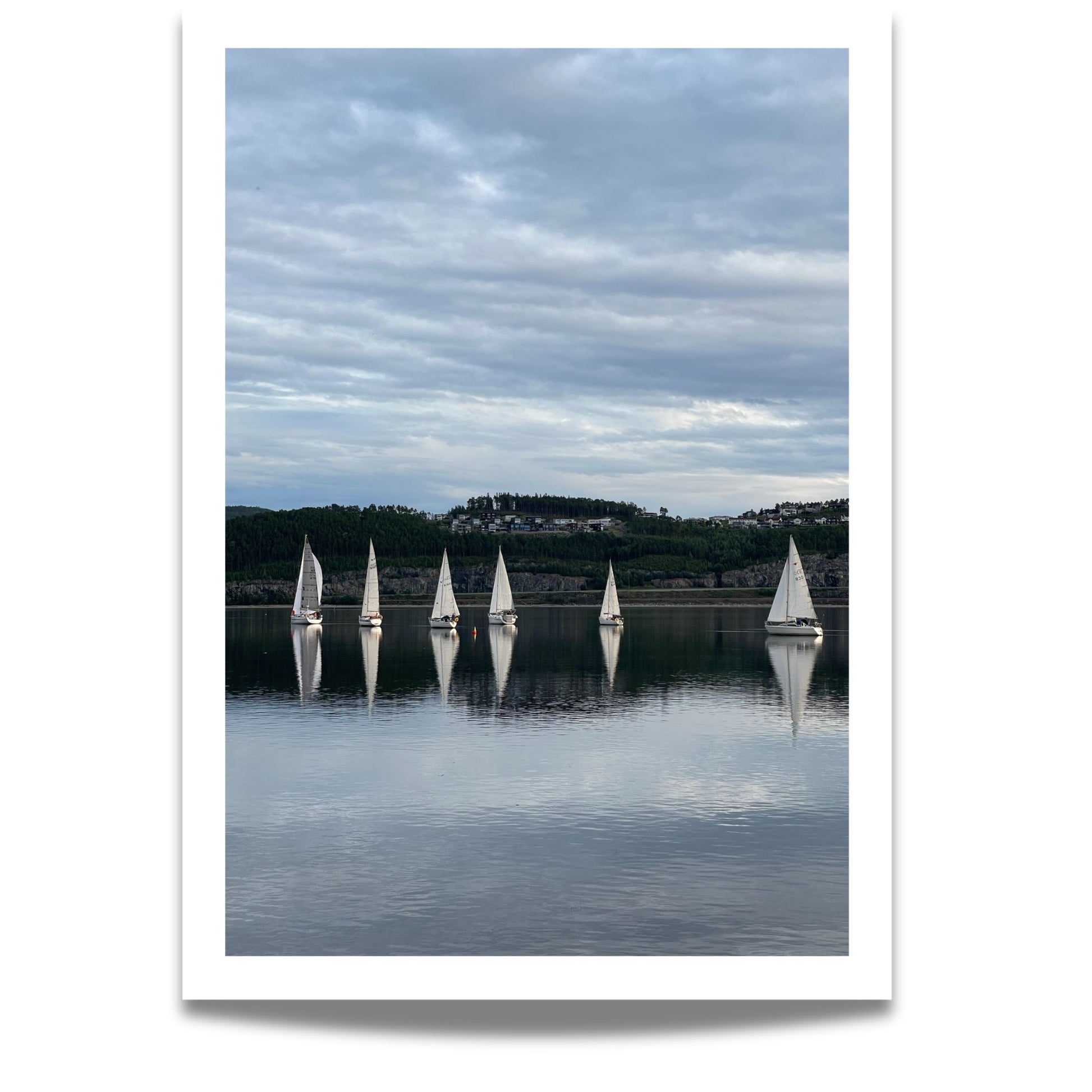 Båtene speiles perfekt i fjorden, omkranset av mørke åser og kveldshimmel. Dette er et elegant og avbalansert motiv som formidler både bevegelse og stillhet – ideelt for sjø- og seilentusiaster.
