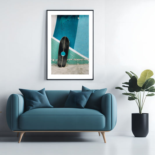 Dette imponerende kunstverket viser et svart skateboard lent opp mot en murvegg, fremhevet av en livlig blå bakgrunn. Illustrasjonsfoto viser motivet som plakat i svart ramme.