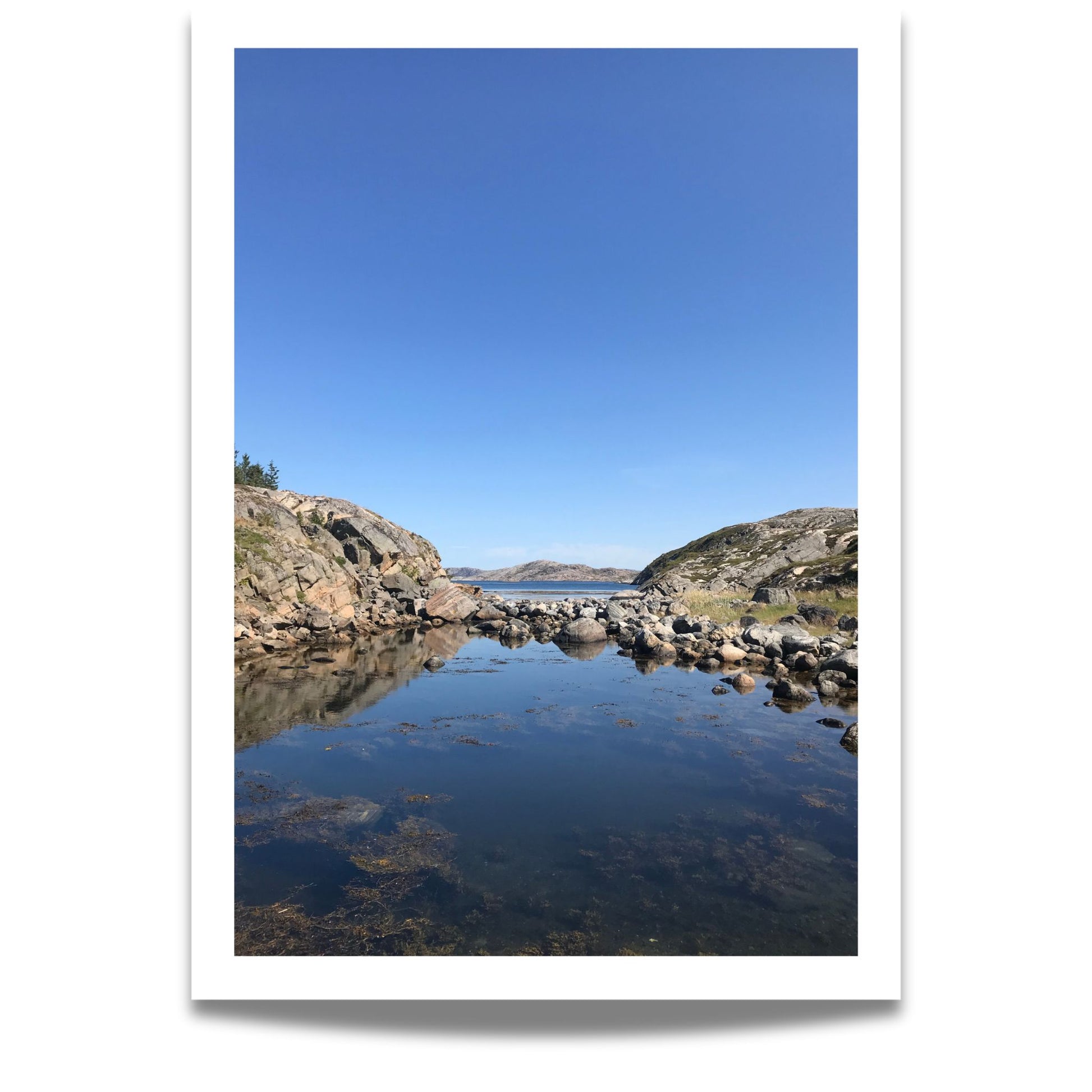 Mellom to klippeformasjoner åpner landskapet seg mot hav og øyer. Dette er et motiv for deg som søker ro, klarhet og den stille storheten som bare norsk kystnatur kan gi.