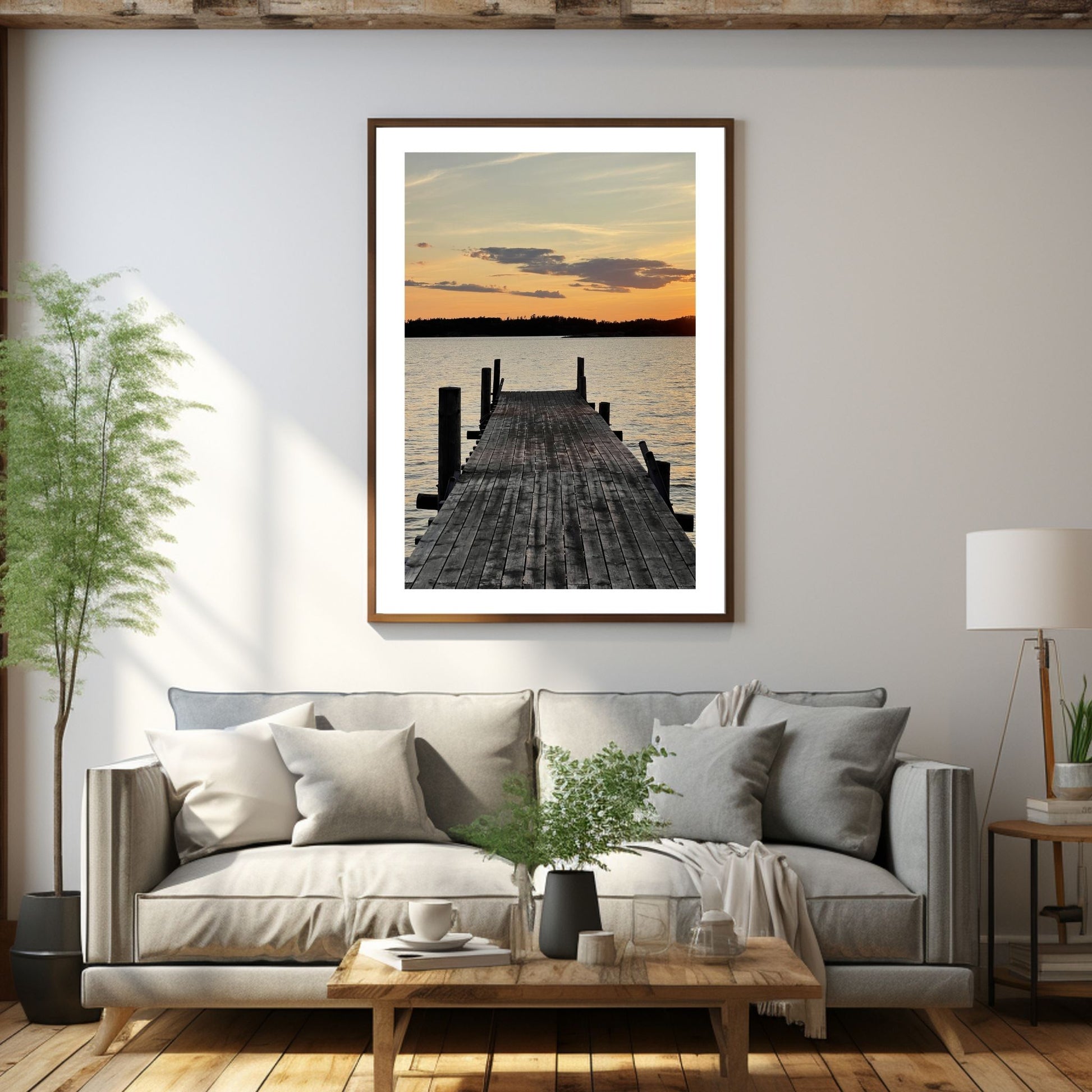 Nydelig solnedgang ved Krokstadfjorden ved Saltnes. Motiv av en brygge som går ute i sjøen, og en sol som er i ferd med å gå ned på en oransje himmel. Fås både som plakat og på lerret. Miljøbildet viser plakaten i en eikeramme som henger på en vegg over en sofa.
