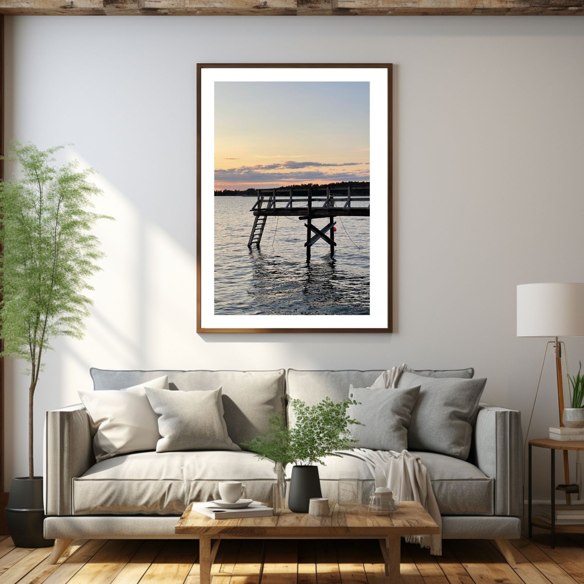 Nydelig solnedgang ved Krokstadfjorden ved Saltnes. Motiv av en brygge som går ute i sjøen, og en sol som er i ferd med å gå ned på en oransje himmel. Fås både som plakat og på lerret. Miljøbildet viser plakaten i en eikeramme som henger på en vegg over en sofa.