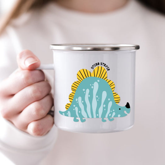Barn som holder emaljekrus med motiv av dinosauren Stego Striper  fra Dino Venneflokken 