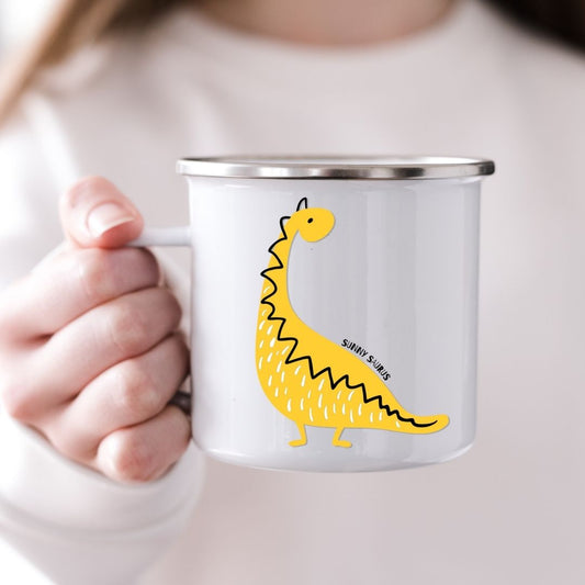 Barn som holder emaljekrus med motiv av dinosauren Sunny Saurus fra Dino Venneflokken