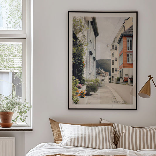 Sydnesgaten viser byens karakteristiske trehusarkitektur, med smale gateløp og intime detaljer som skaper en særegen atmosfære. Illustrasjon viser plakat o sort ramme.