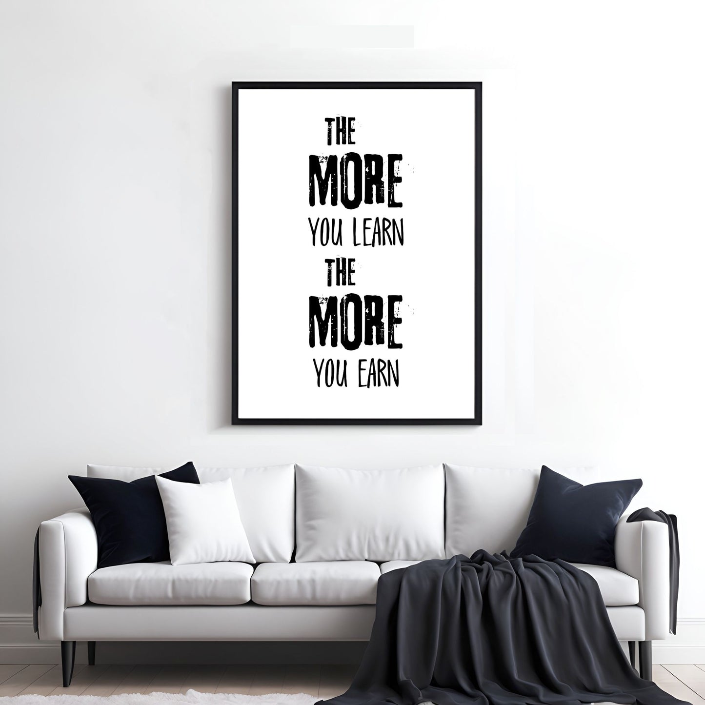 Grafisk tekstplakat med sort skrift på hvit bakgrunn og tekst "The more yoy learn, the more you learn". Illustrasjon viser plakat i sort ramme på en vegg over en sofa.