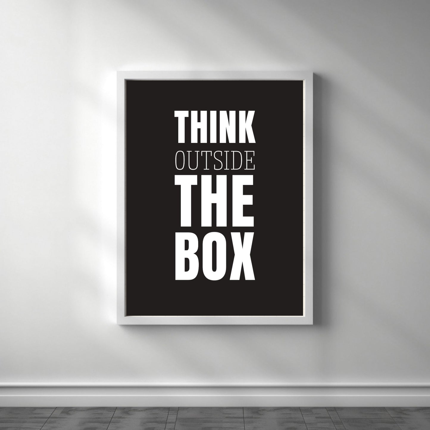 Grafisk plakat med hvit skrift på sort bakgrunn. Tekst på plakat "Think outside the box" Illustrasjon viser plakat i hvit ramme.