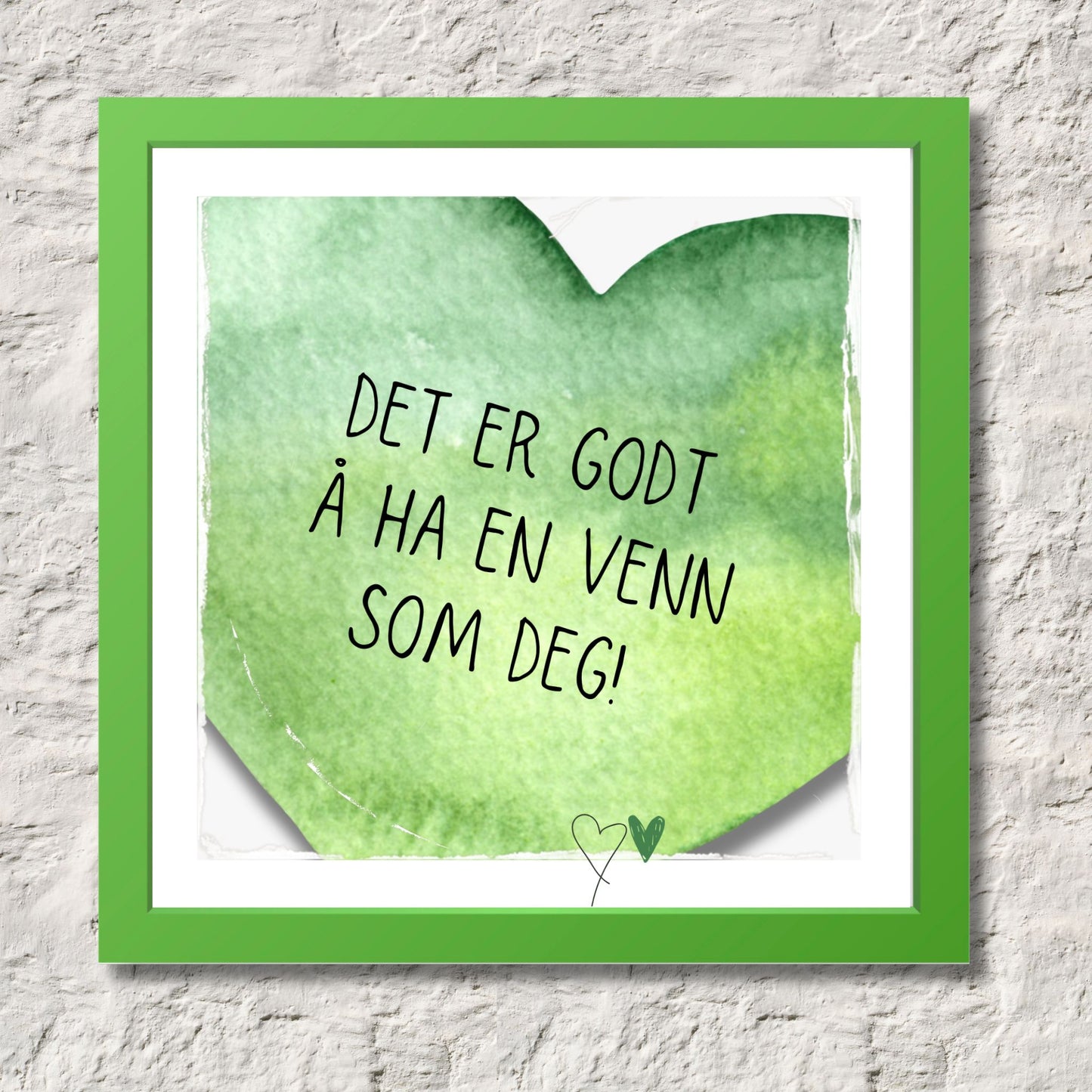 Plakat med grønt hjerte og tekst "Det er godt å ha en venn som deg". Med hvit kant på 1,5 cm.  Illustrasjon viser plakat i grønn ramme.