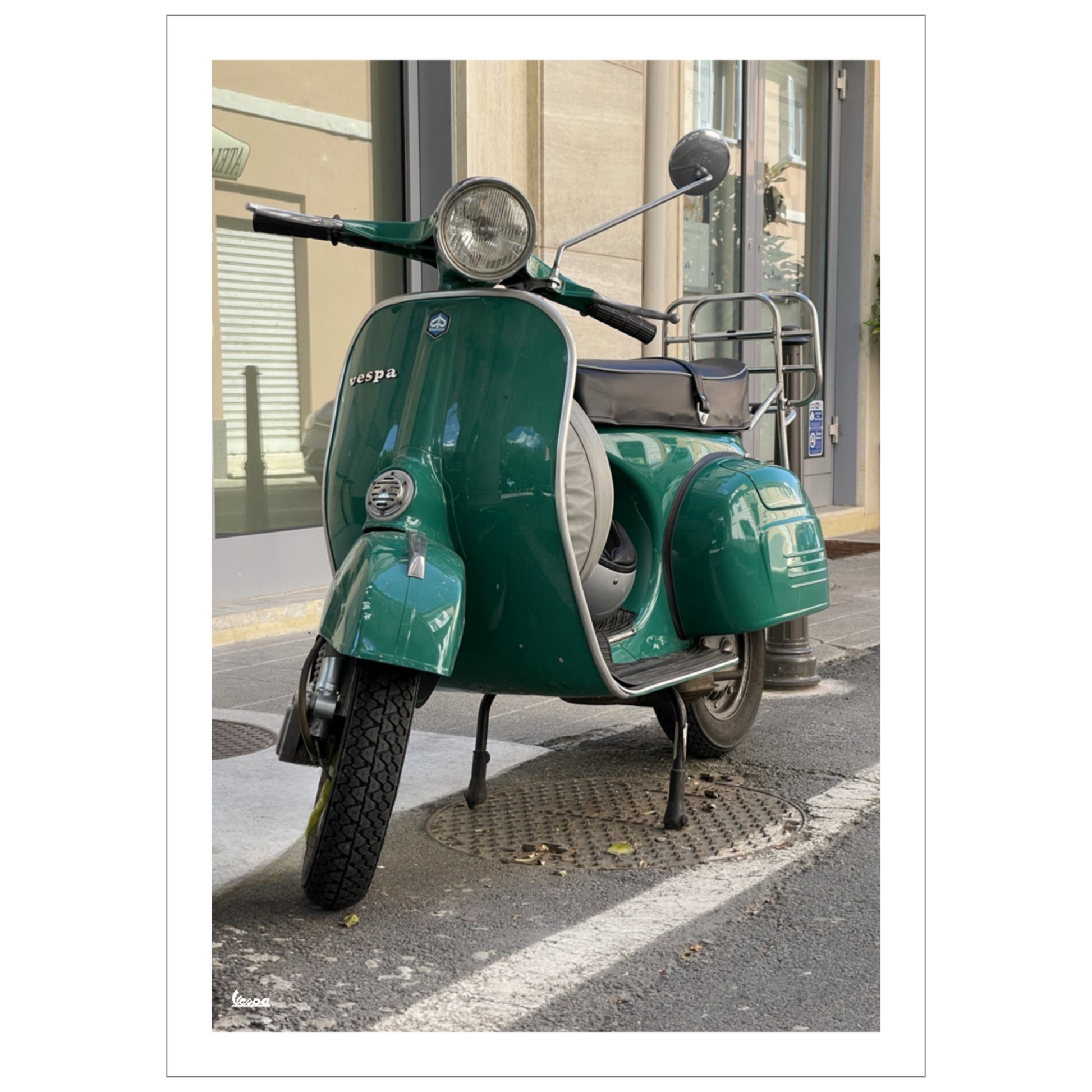 Fotografi av en grønn Vespa parkert foran en bygning i en gate i Italia. Plakaten har en hvit kant.