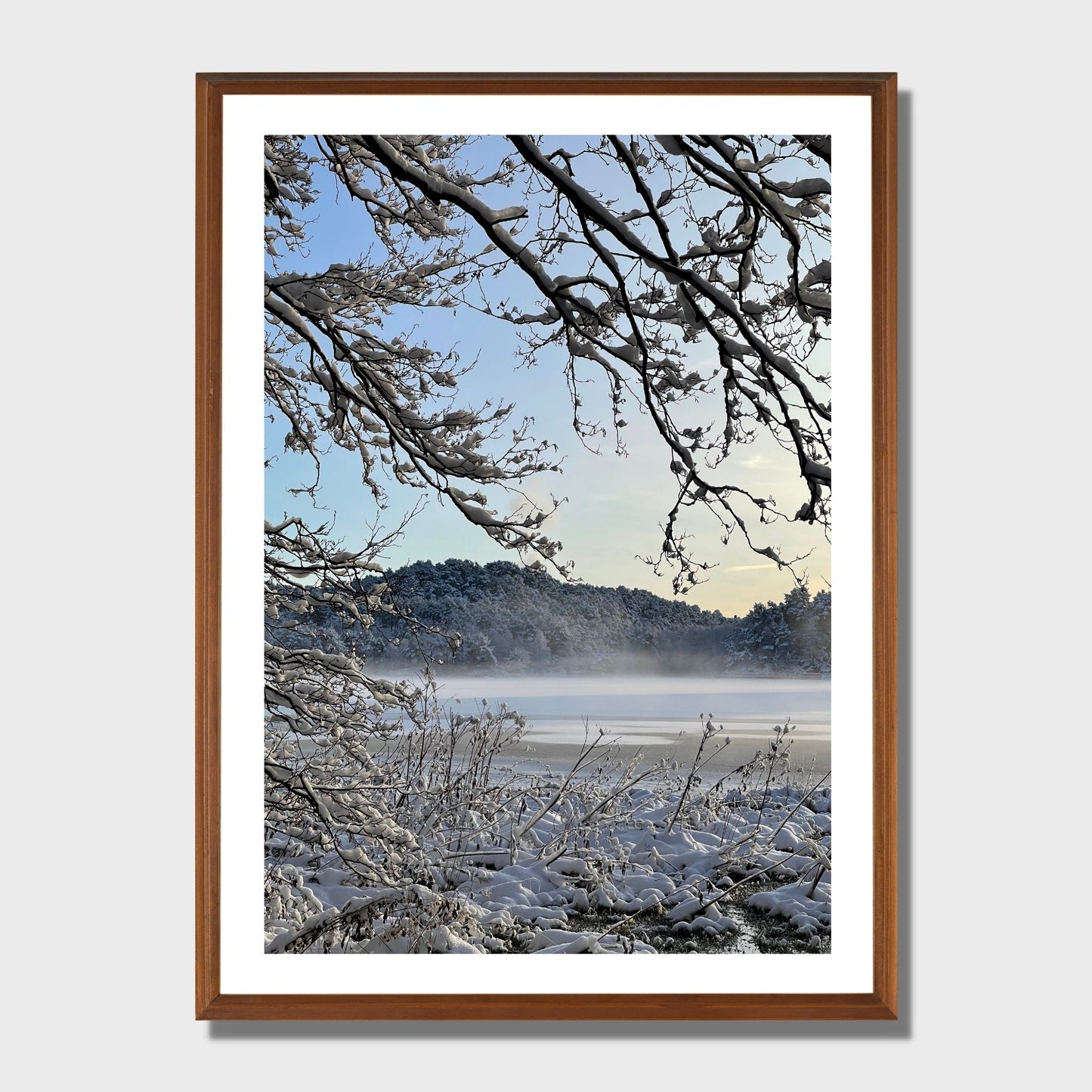 Magisk vinterdag ved Skranevatnet med desembersol og frostrøyk på isen. Illustrasjon viser plakat i eikeramme.