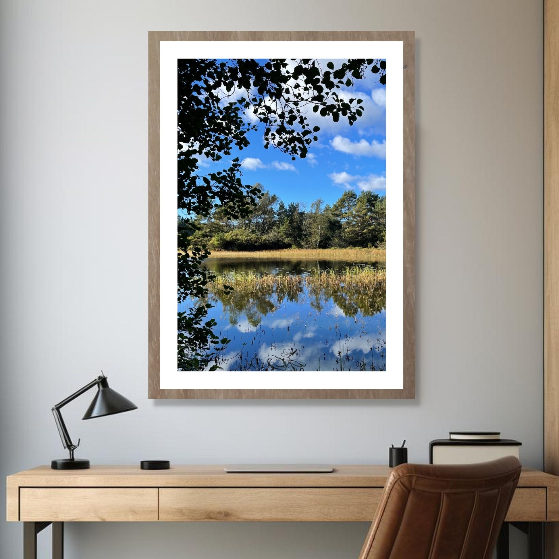 Dette motivet fanger en perfekt dag i september, med speilblankt vann som reflekterer den klare blå himmelen og de omkringliggende trærne. illusrasjon viser plakat i ramme.