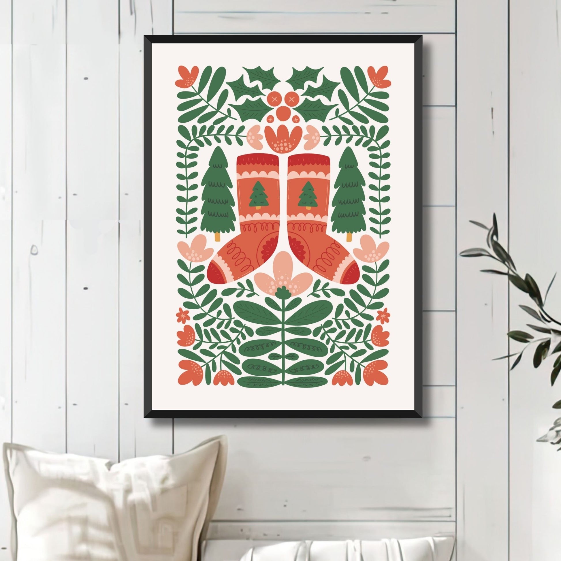 "Vinterglede" er en leken og koselig plakat som viser et par røde, strikkede julestrømper omkranset av vintergrønt. Illustrasjonsfoto viser plakat i sort ramme.