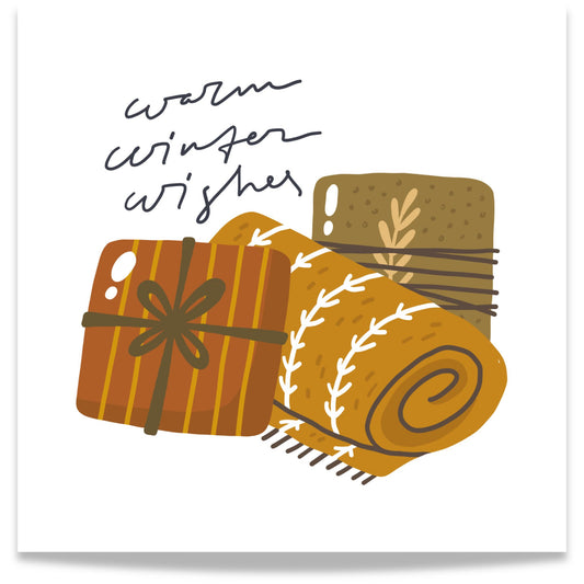 Et harmonisk motiv med teksten Warm Winter Wishes, hvor gaver og et sammenrullet pledd skaper en følelse av komfort og ro. 