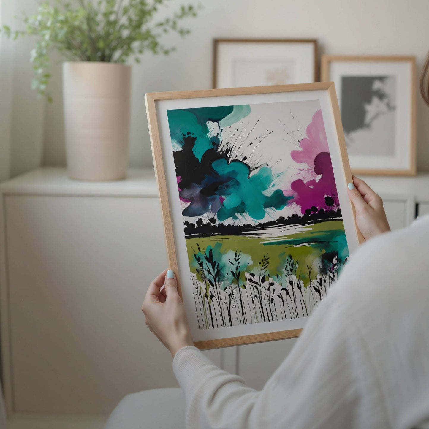 Wild Horizon – abstrakt naturplakat forener det ville og det vakre i ett levende kunstverk. Med kraftfulle blekk-lignende strøk og fargeeksplosjoner i turkis, grønt og rosa. Illustrasjon viser plakat med hvit kant i eik ramme.