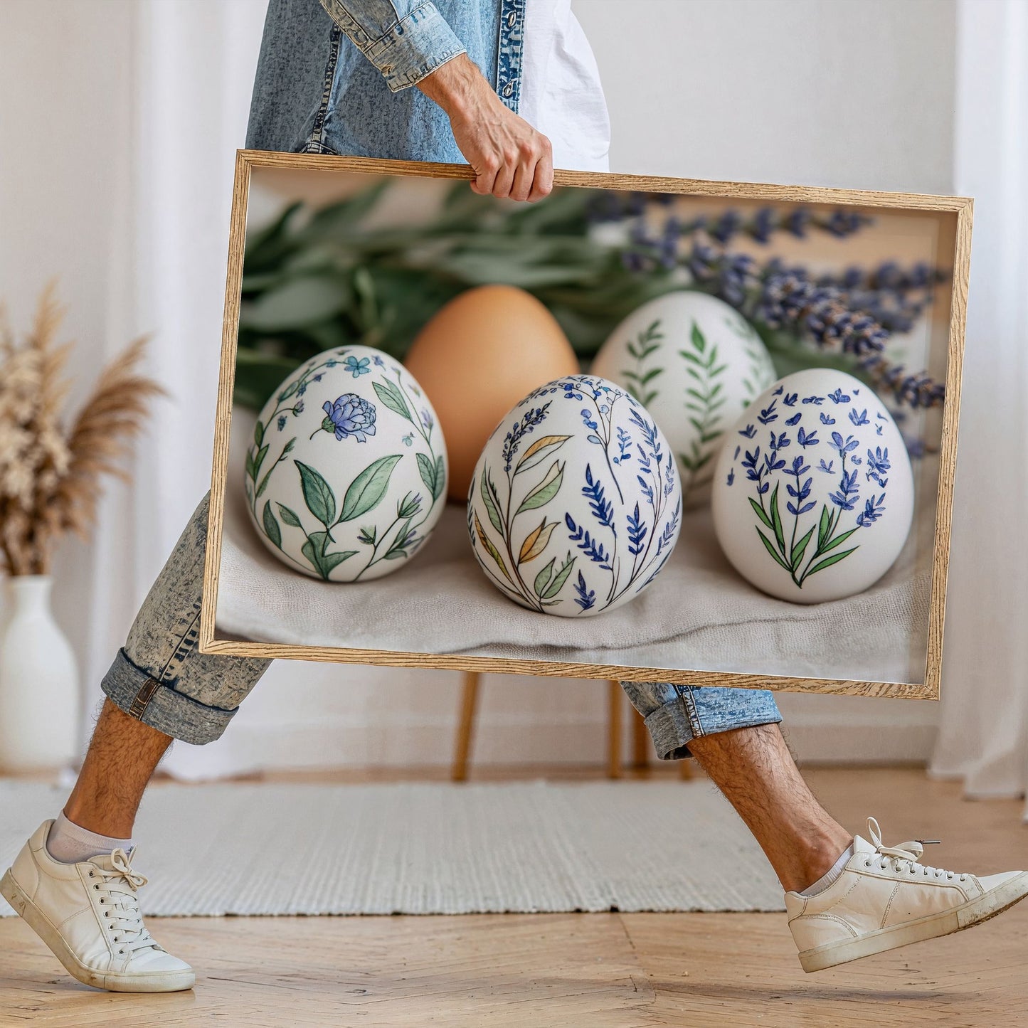 Påskeplakat med blomstrete egg i treramme holdt i hånd