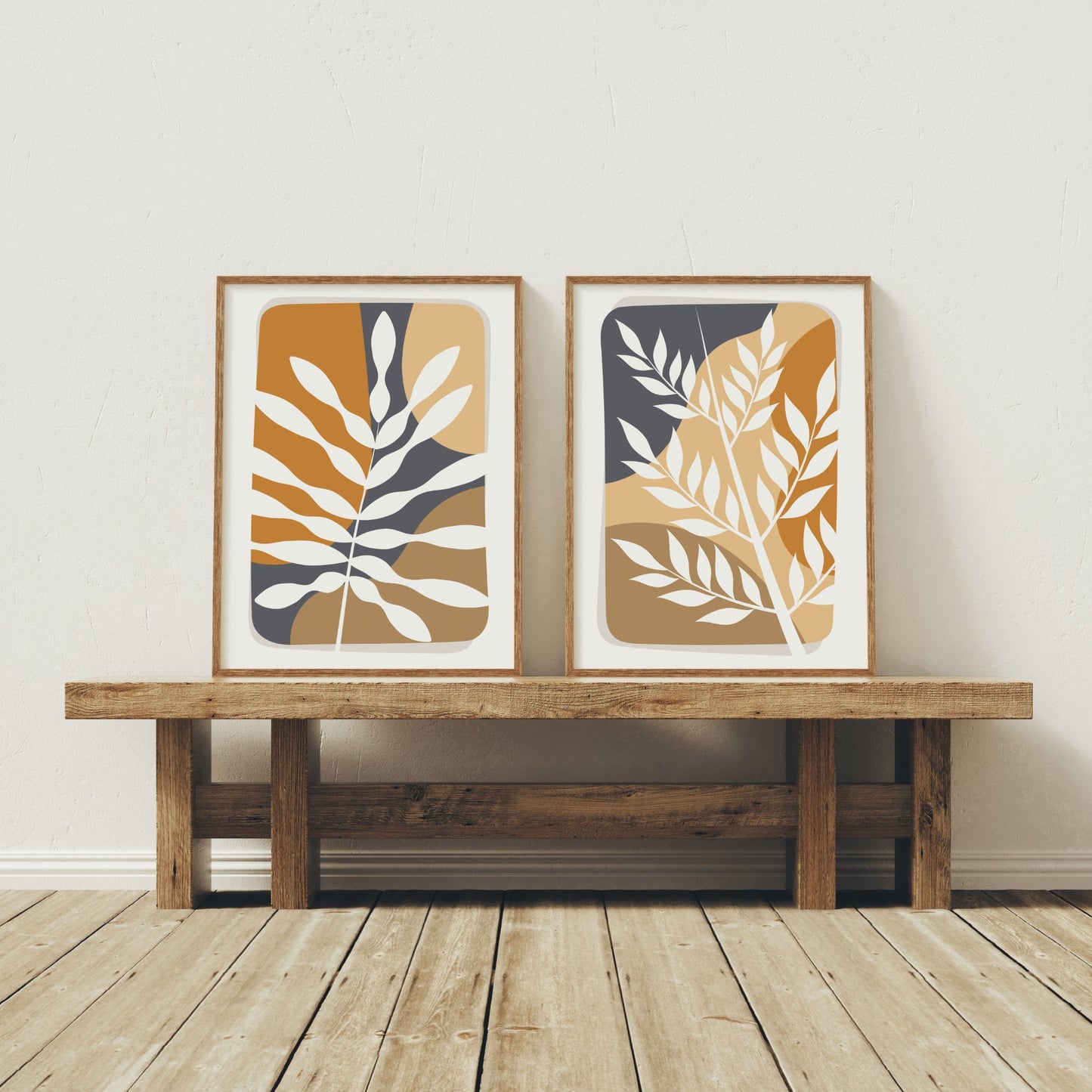 Botanical Layers og Wild Botanicals boho-plakater med stiliserte blader i trerammer på benk