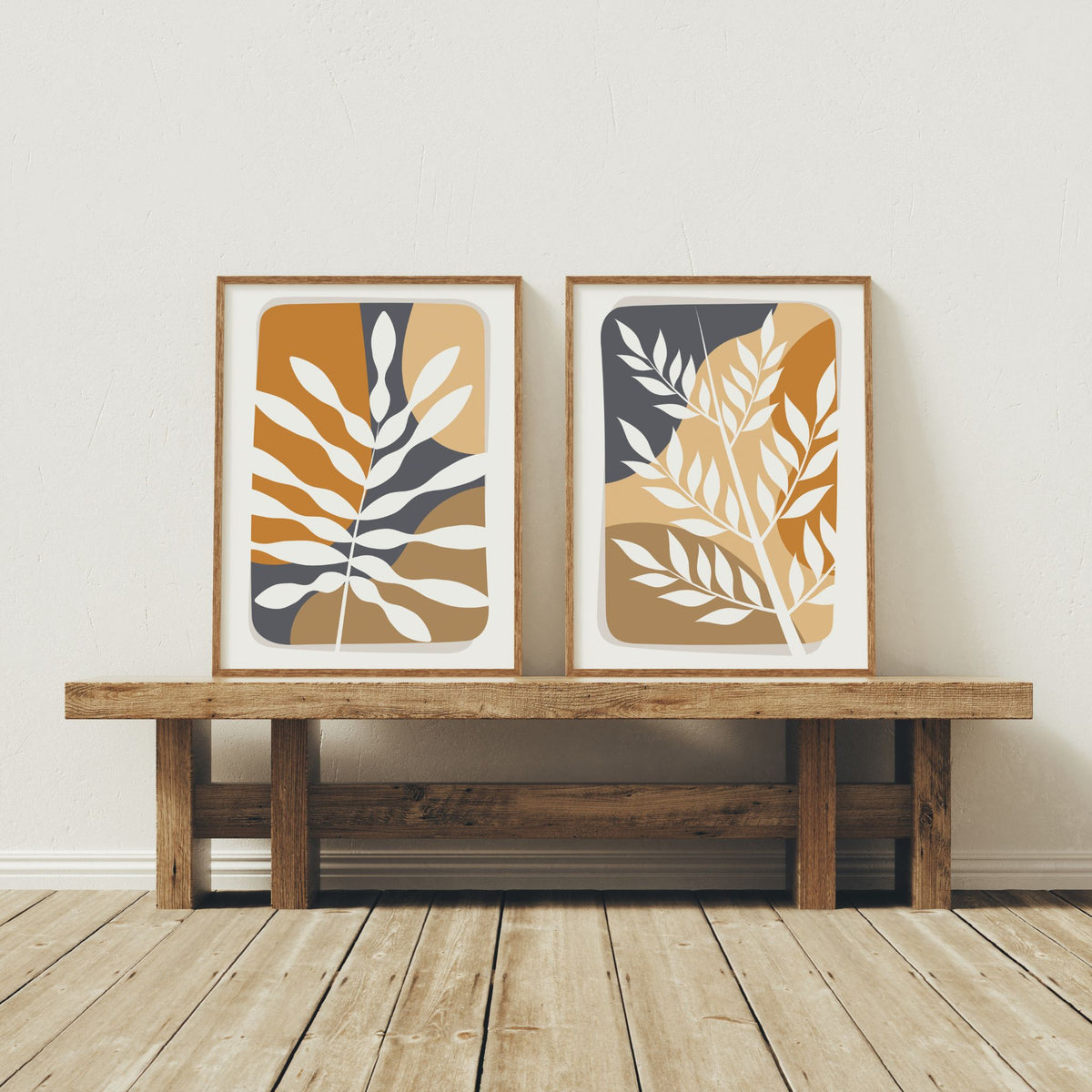 Botanical Layers og Wild Botanicals boho-plakater med stiliserte blader i trerammer på benk