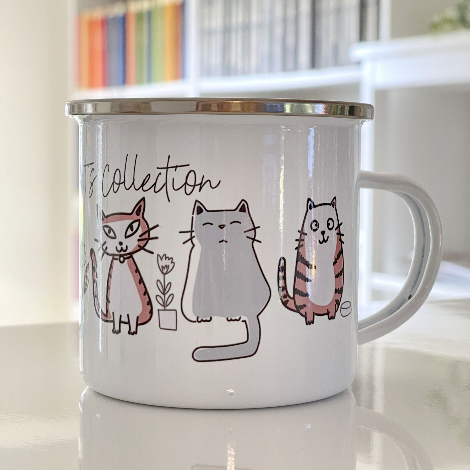 Emaljekrus med illustrerte kattemotiver i myke farger
