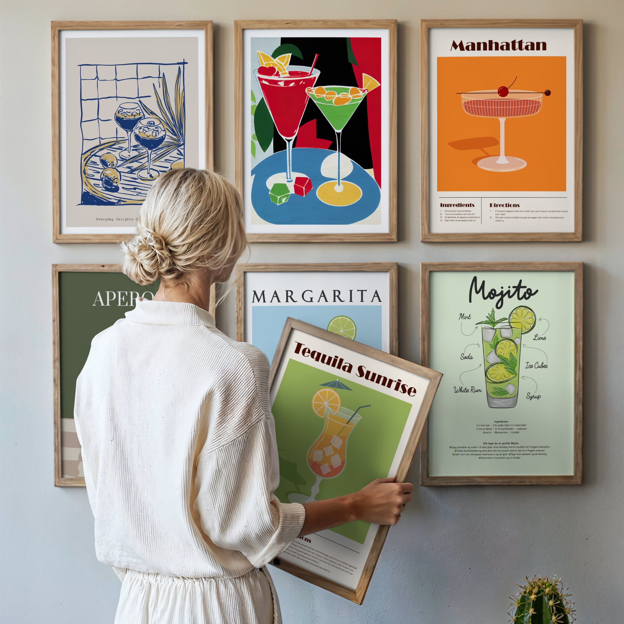 Cocktailplakater på vegg med klassiske drinker som margarita, mojito og aperol i stilrent hjem