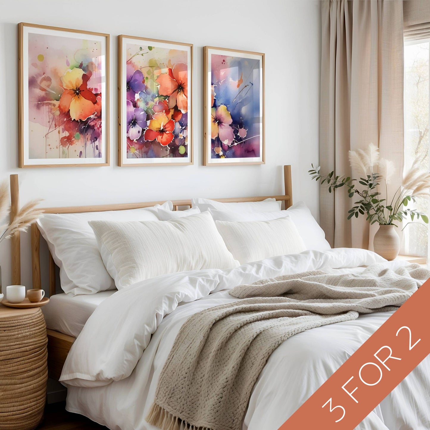 Color Splash Bloom Collection med tre fargerike blomsterplakater i akvarellstil vist over seng i lyst nordisk soverom
