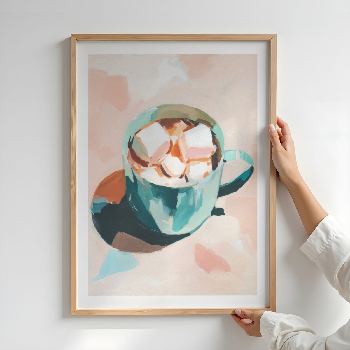 Person holder Cozy Cocoa plakat med hvit kant i lys treramme