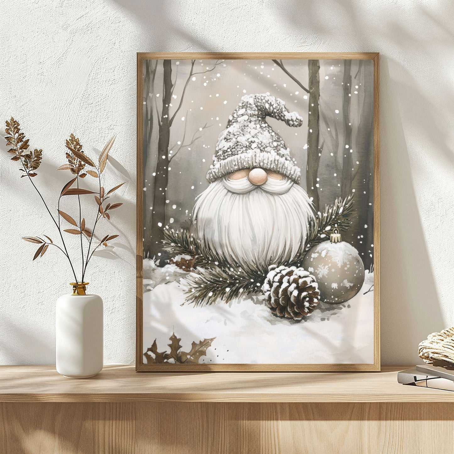 Nisse med snø i skjegget sitter omgitt av furukvister, kongle og julekule i et snødekt vinterlandskap. Illustrasjon viser plakat med hvit kantlinje i eik rmme.