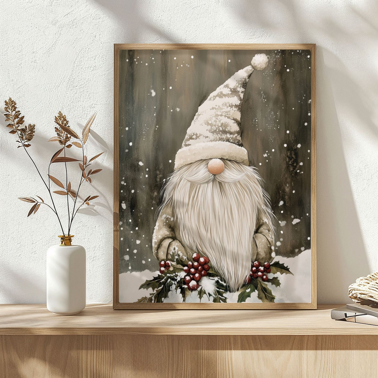 Nisse med lang lue står i snøen omgitt av kristtorn og røde bær i et vinterlandskap. Illustrasjon viser plakat uten hvit kantlinje i eik ramme.