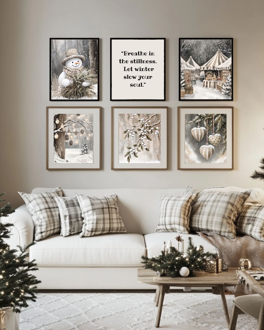 Veggdekorasjon med seks vinterplakater fra Cozy Winter Story Collection over sofa i lyse toner, omgitt av juletrær og vinterlig interiør.