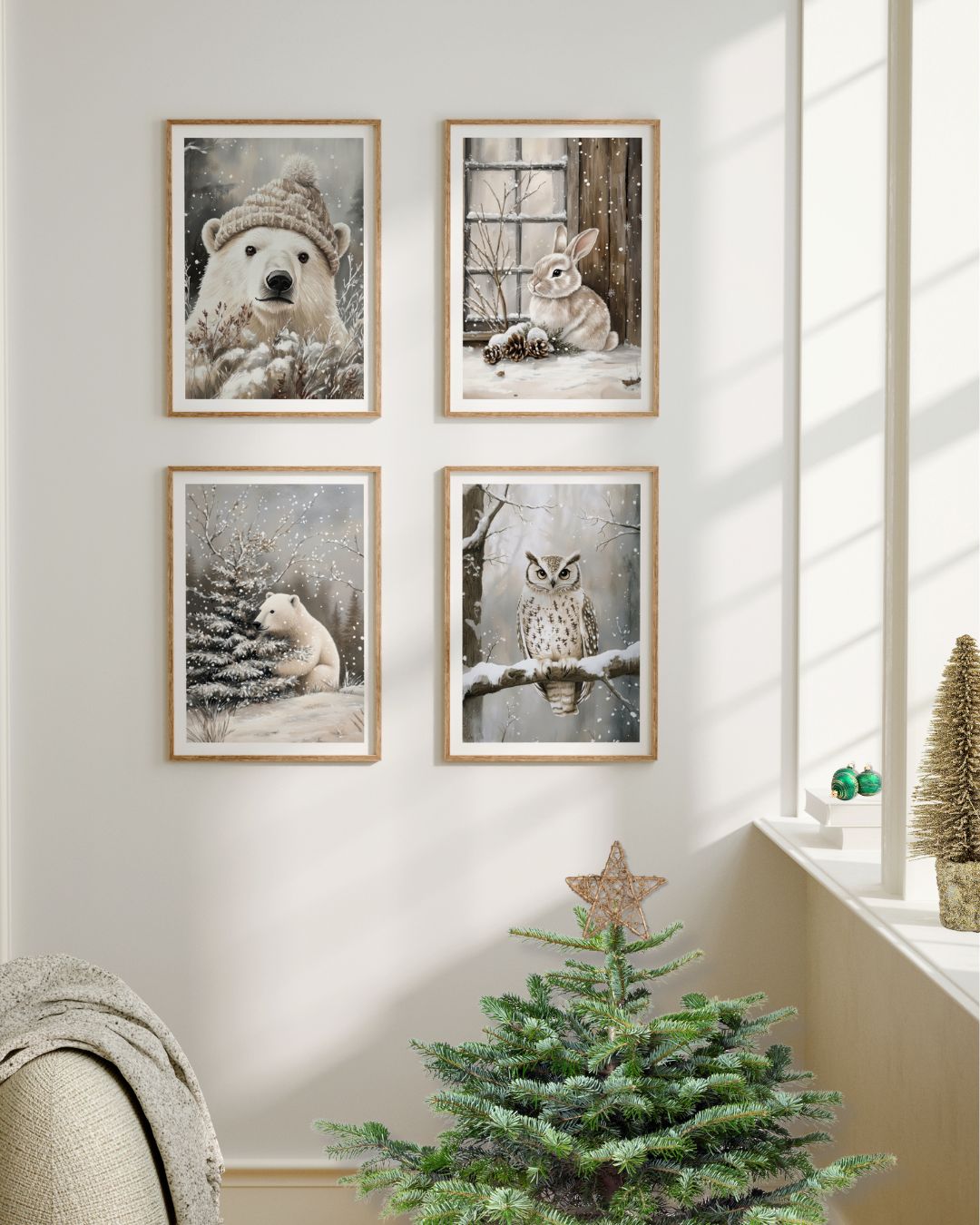 Fire vinterplakater fra Cozy Winter Story Collection med motiver av ugle, kanin og isbjørn, vist på lys vegg ved et lite juletre i naturinspirert interiør.