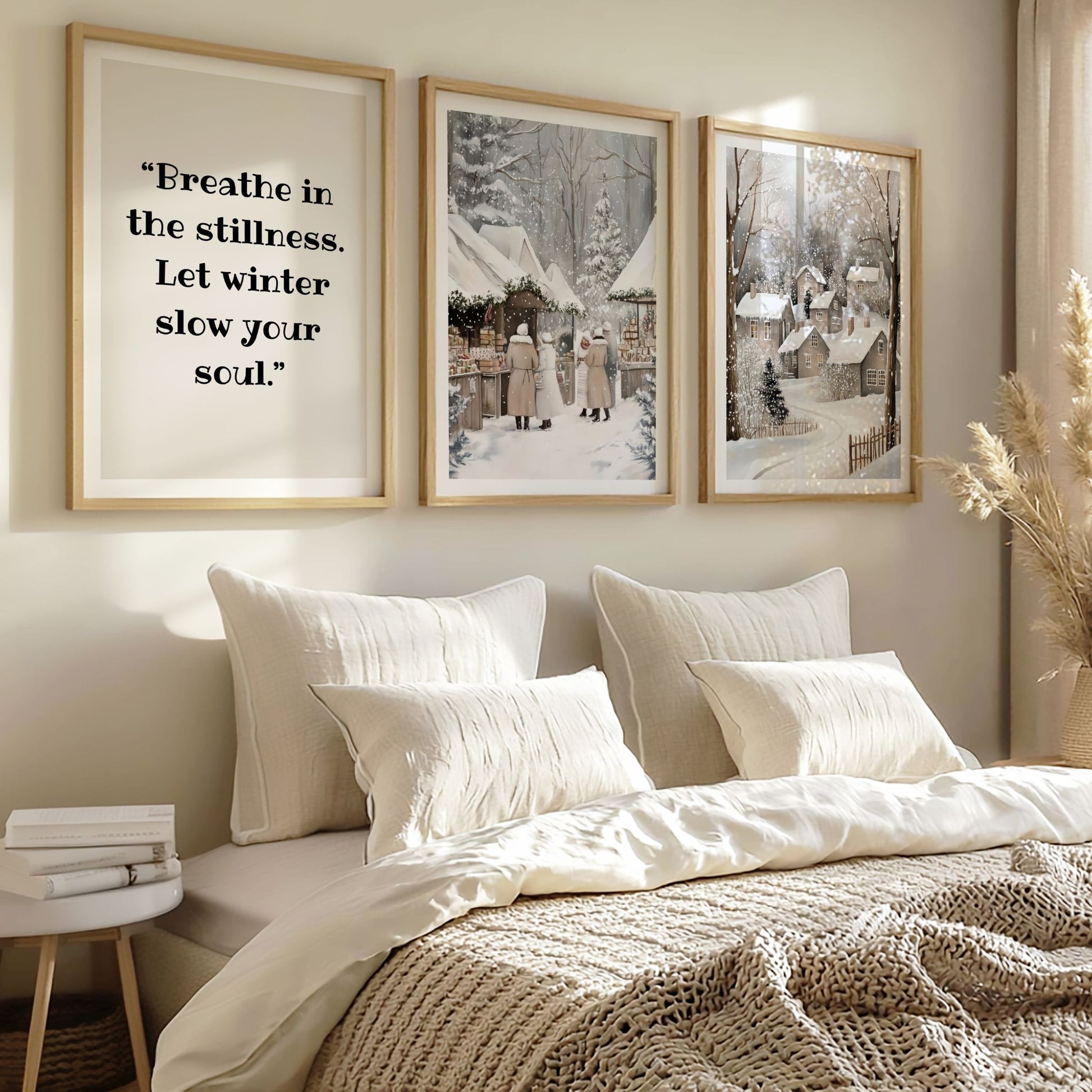 Plakat med teksten “Breathe in the stillness. Let winter slow your soul.” stylet over en seng i et lyst, nordisk soverom.
