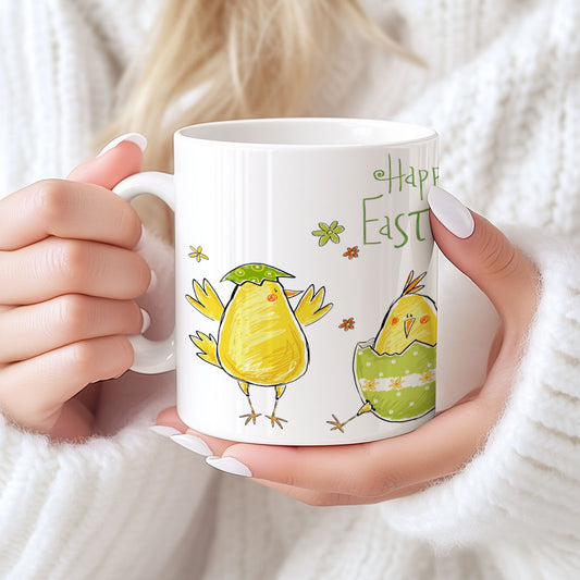 Keramikkrus med håndtegnet påskekylling og teksten Happy Easter, holdt i hendene foran lys bakgrunn.
