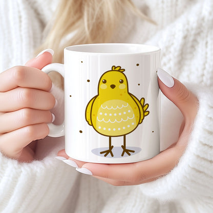 Påskekrus i keramikk med nyklekt gul kylling i blått prikkete egg, holdt i hendene foran lys bakgrunn.