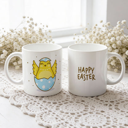 Happy Easter påskekrus med gul kylling i blått eggeskall, vist fra begge sider på hvit blondeduk.