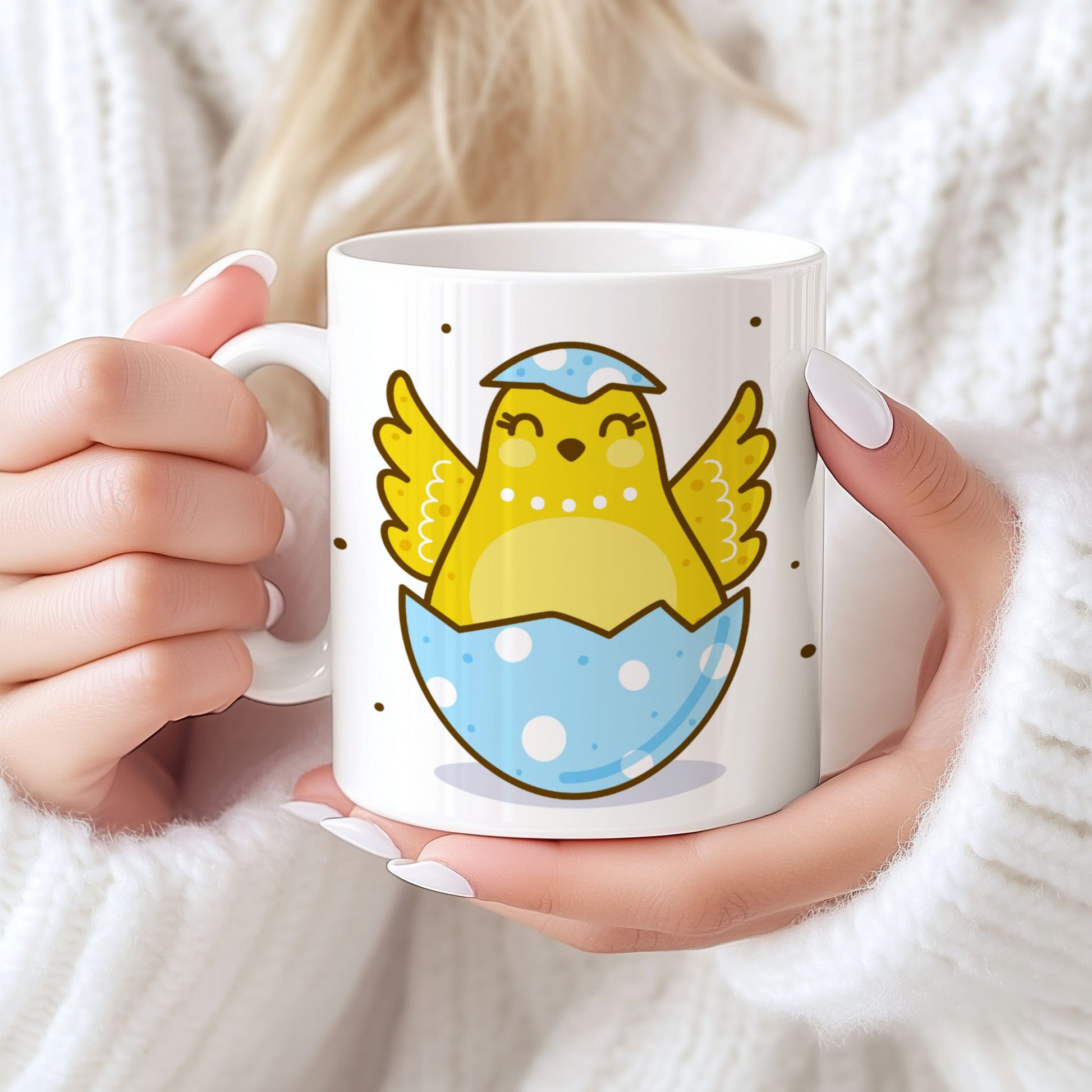 Påskekrus i keramikk med nyklekt gul kylling i blått prikkete egg, holdt i hendene foran lys bakgrunn.