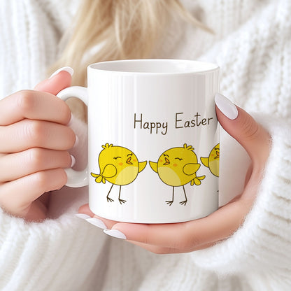 Keramikkrus med flere gule påskekyllinger på rekke og teksten Happy Easter, holdt i hendene foran lys bakgrunn.
