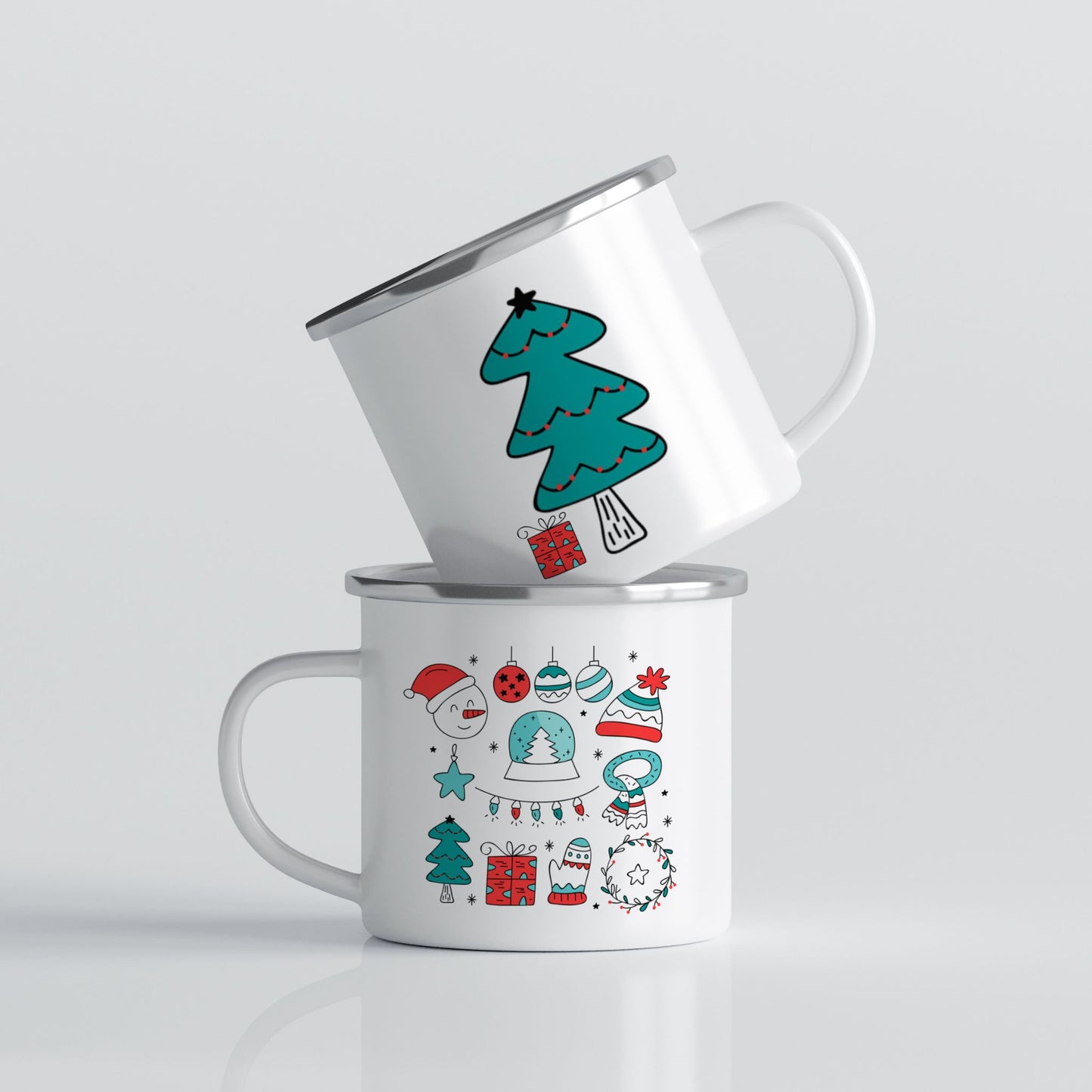 Hvitt emaljekrus med to grafiske julemotiver: fargerike juleikoner og et stilisert turkist juletre med gave.