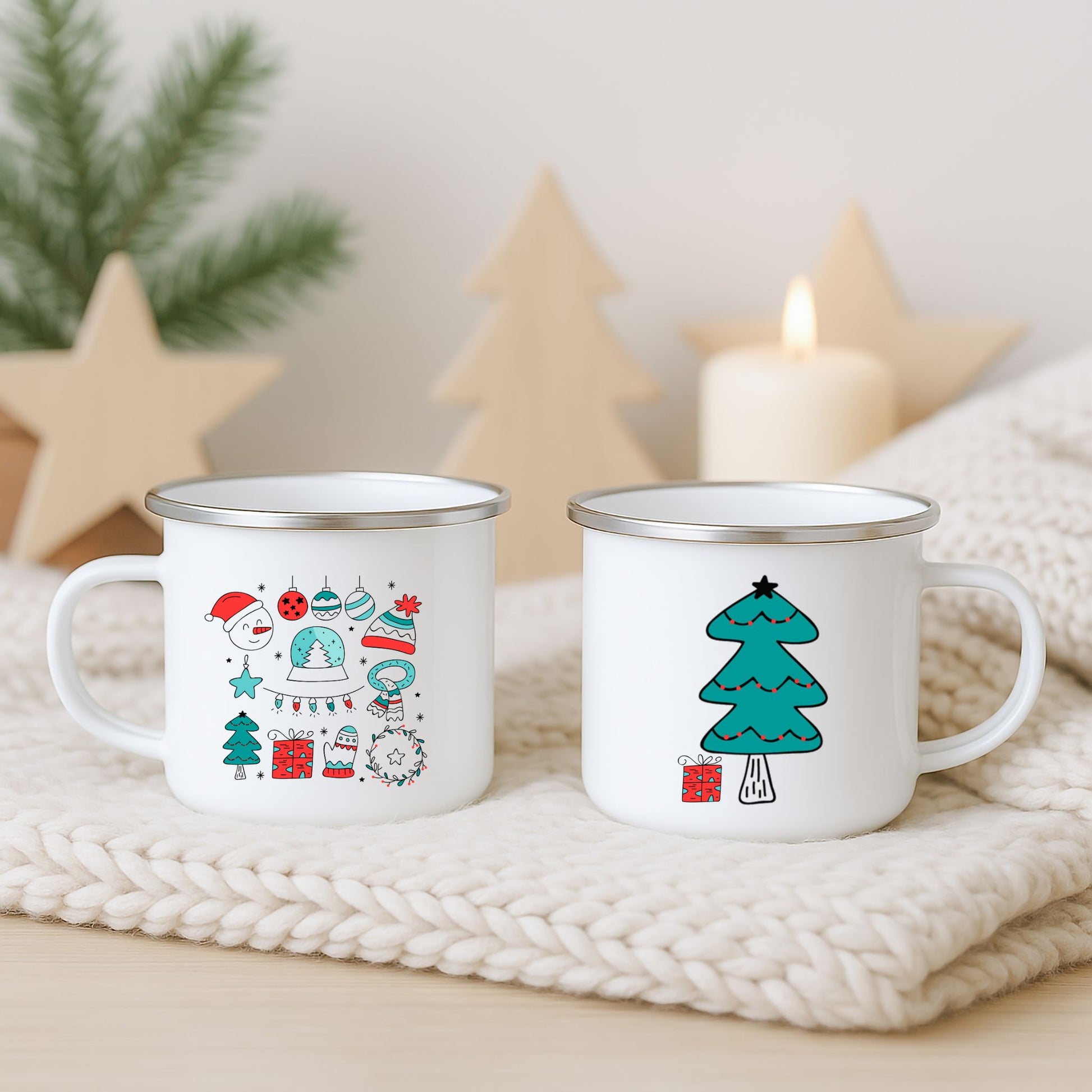 Hvitt emaljekrus med to grafiske julemotiver: fargerike juleikoner og et stilisert turkist juletre med gave, fotografert på lys strikket duk med juledekor i bakgrunnen.