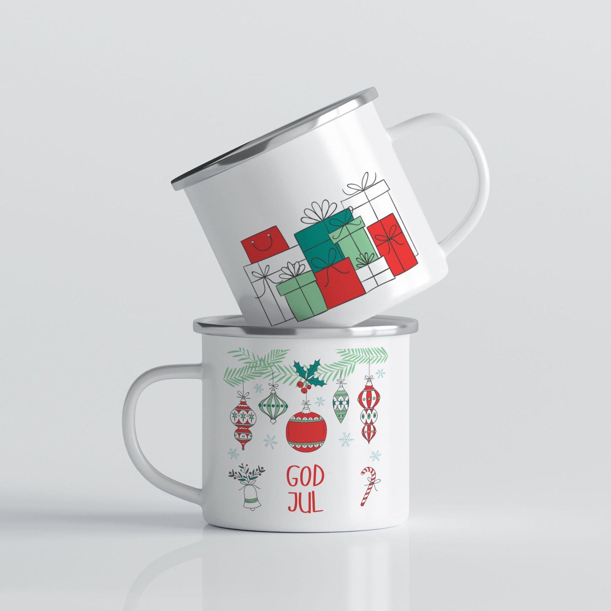 Hvitt emaljekrus med to grafiske julemotiver: hengende ornamenter med teksten «God Jul» og en minimalistiske julegaver i rødt og grønt.