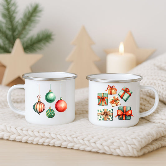 Hvitt emaljekrus med fire hengende julekuler på én side og julepakker med sløyfer på den andre, fotografert på lys strikket duk med juledekor i bakgrunnen.