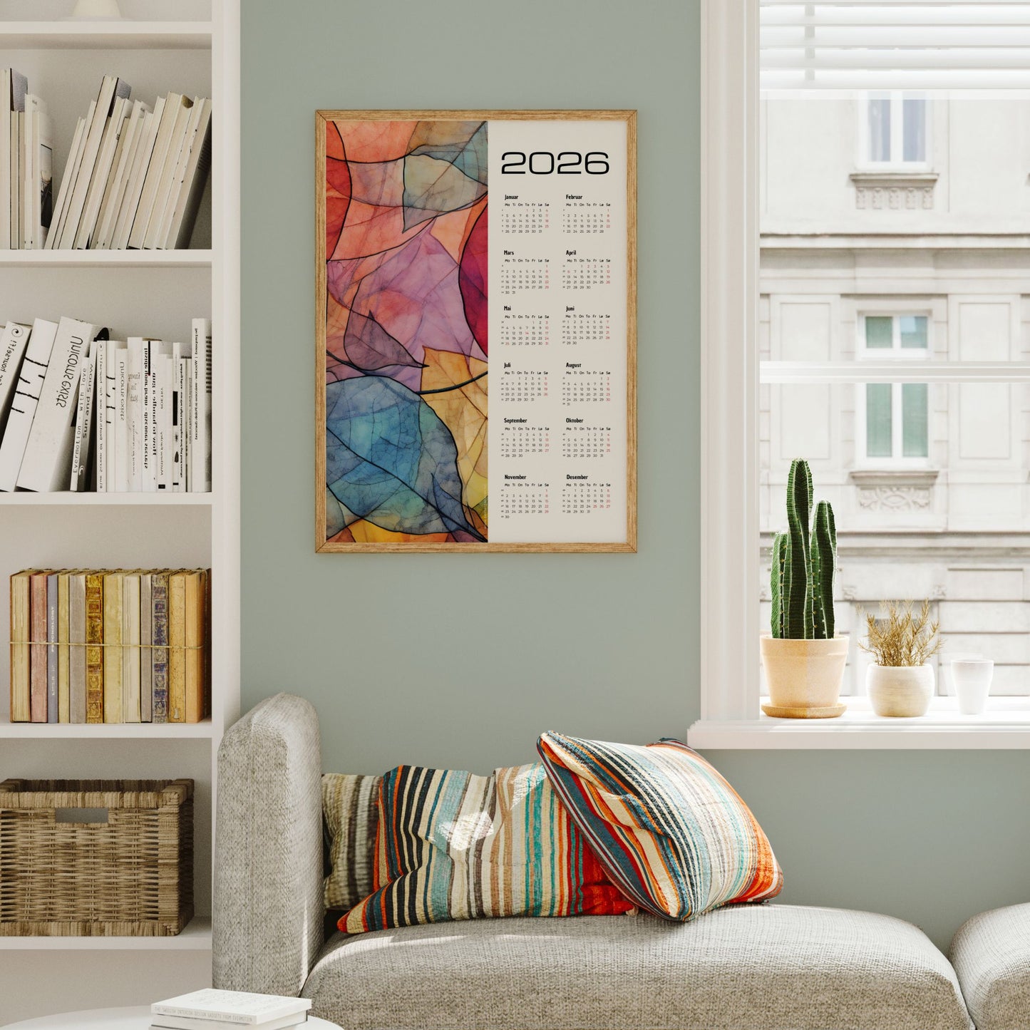 Kalender 2026 med abstrakt bladmotiv i farger og moderne kalenderlayout. Illustrasjon viser kalender i eik ramme.
