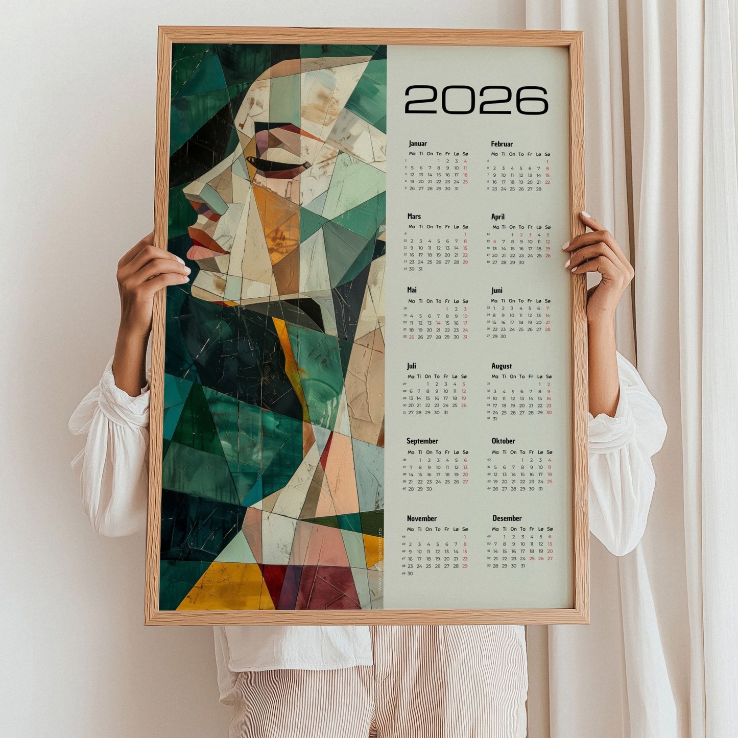 Kalender 2026 med abstrakt kvinneportrett i geometriske former og harmoniske farger, kombinert med helårsoversikt. Illustrasjon viser kalender i eik ramme.