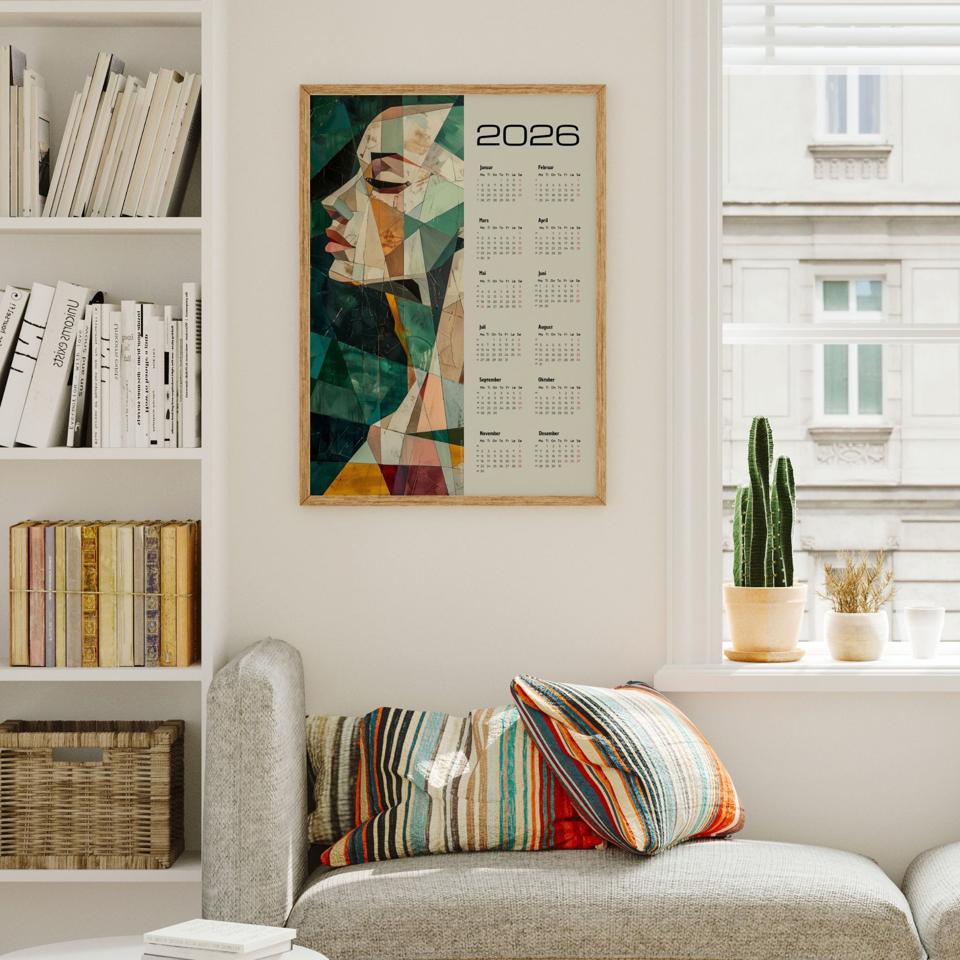 Kalender 2026 med abstrakt kvinneportrett i geometriske former og harmoniske farger, kombinert med helårsoversikt. Illustrasjon viser kalender i eik ramme.