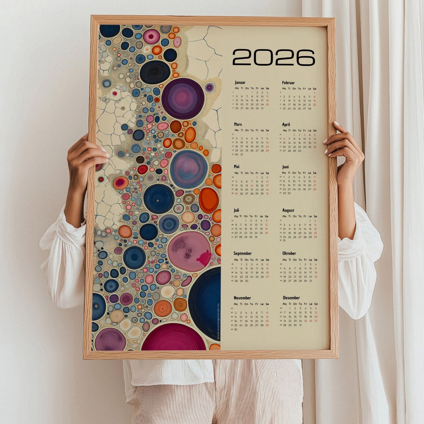 Kalender 2026 med fargerike abstrakte sirkler i ulike størrelser og årskalender på høyre side. Illustrasjon viser kalender i eik ramme.