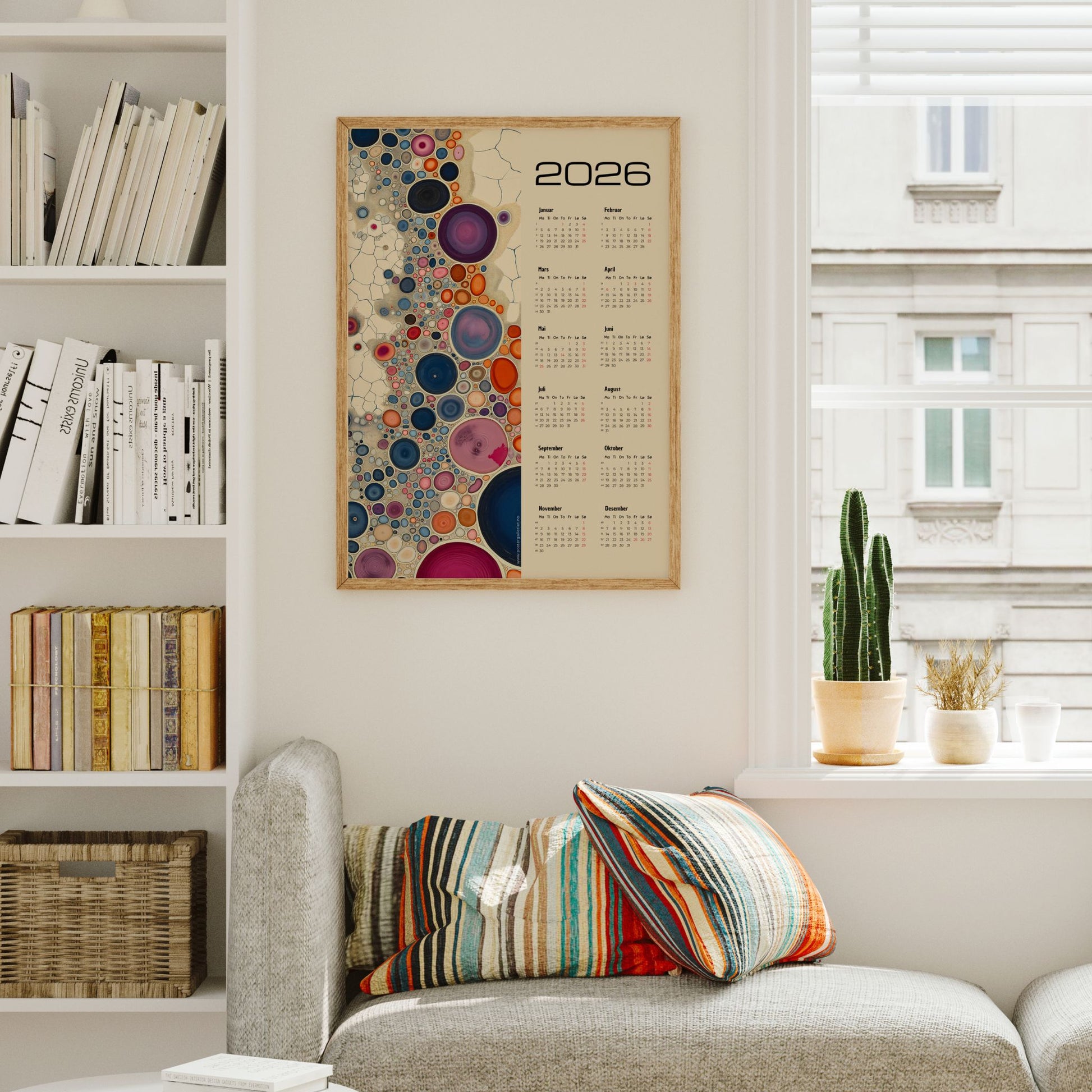 Kalender 2026 med fargerike abstrakte sirkler i ulike størrelser og årskalender på høyre side. Illustrasjon viser kalender i eik ramme.