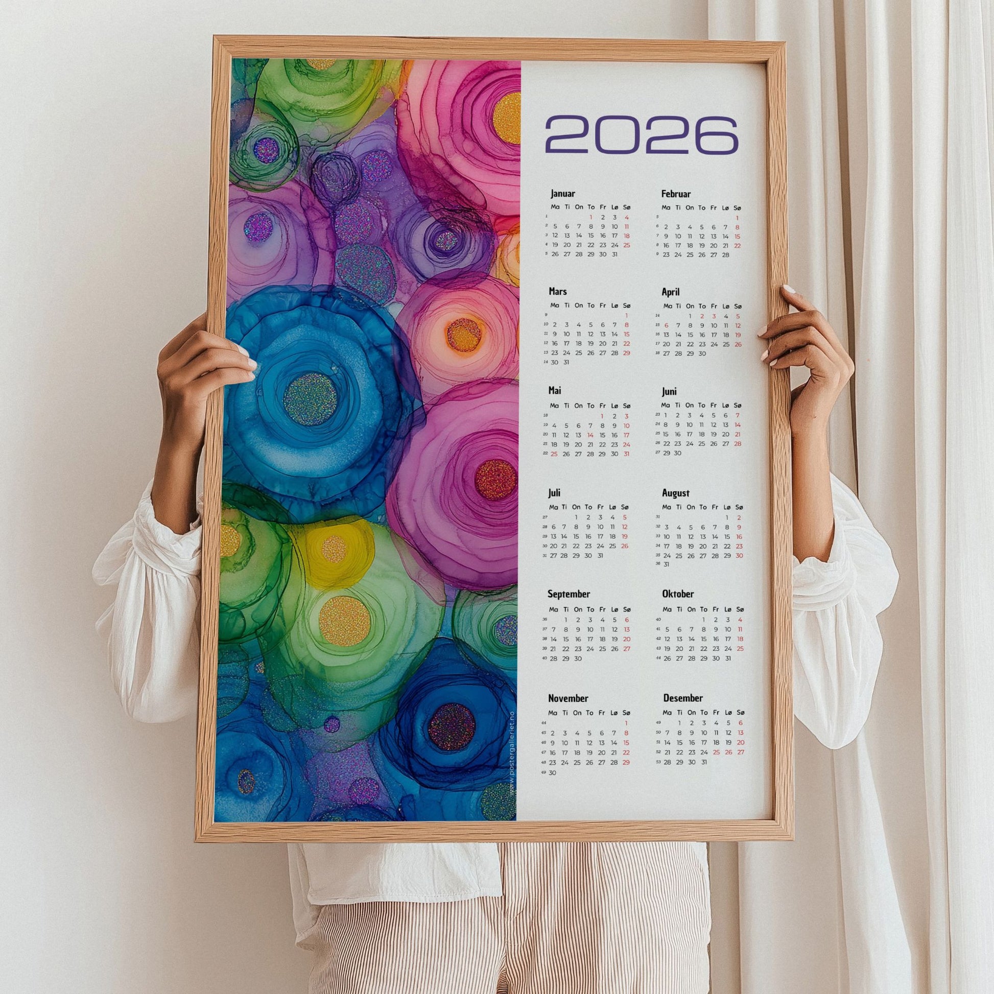 Kalender 2026 med alkoholink-inspirerte sirkler i klare, fargerike toner. Illustrasjon viser kalender i eik ramme.