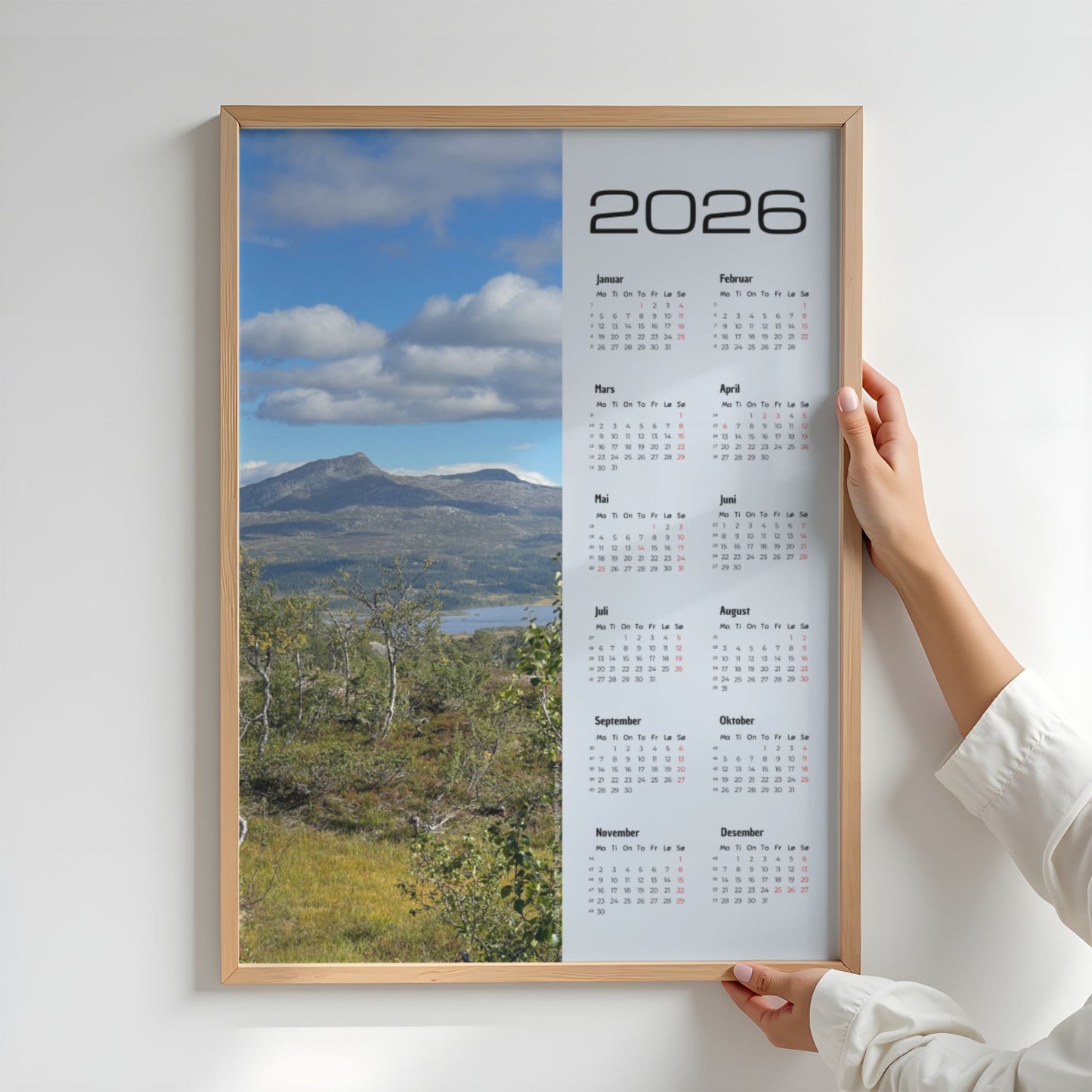 Kalender 2026 med foto av Dærgafjellet i Røyrvik, sett over fjellterreng og høstlig vegetasjon. Illustrasjon viser kalender i eik ramme.