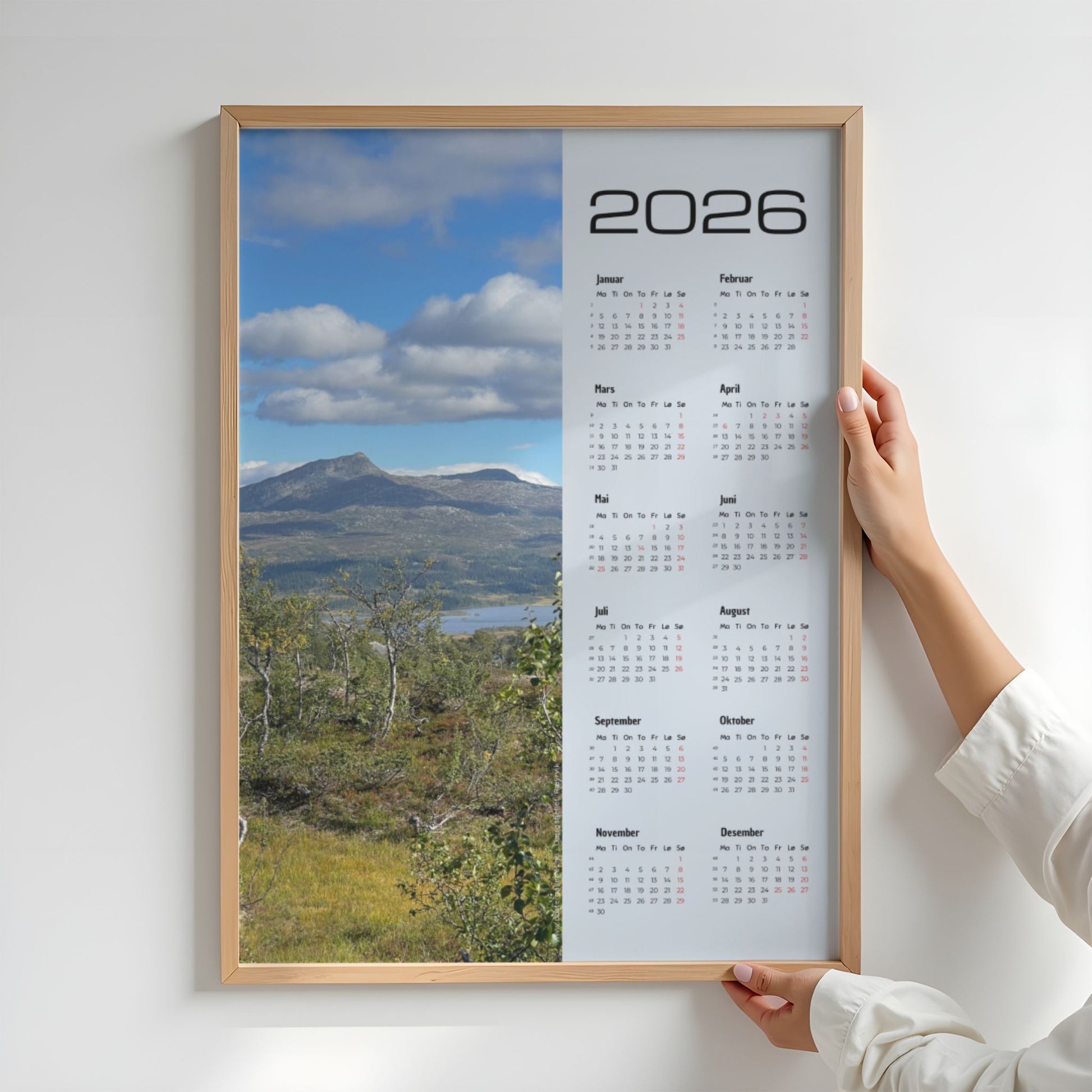 Kalender 2026 med foto av Dærgafjellet i Røyrvik, sett over fjellterreng og høstlig vegetasjon. Illustrasjon viser kalender i eik ramme.