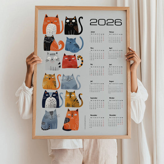 Grafisk kalender 2026 med fargerik katteillustrasjon og moderne layout. Illustrasjon viser kalender i eik ramme.