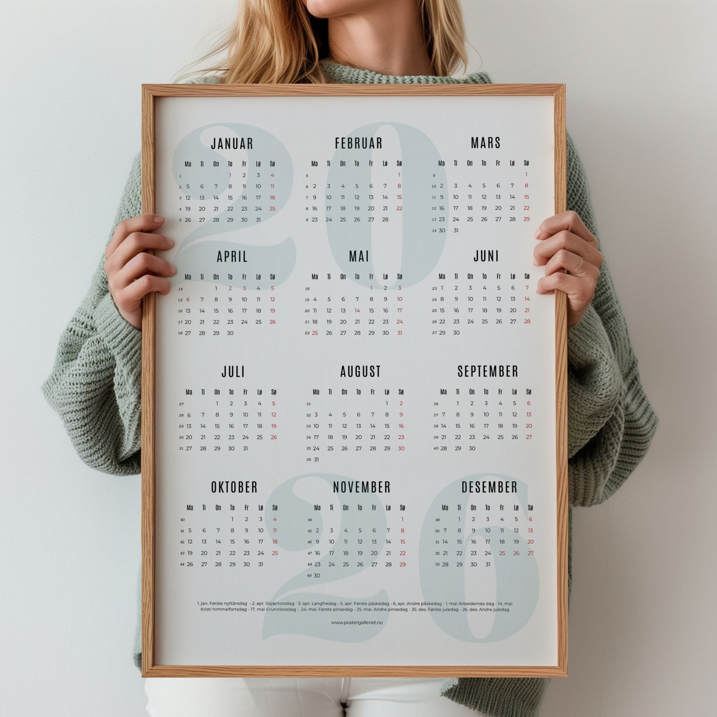 Minimalistisk årskalender 2026 med stort, dempet grønt årstall i bakgrunnen og tydelig kalenderoppsett. Illustrasjon viser kalender med grønt årstall i eik ramme.